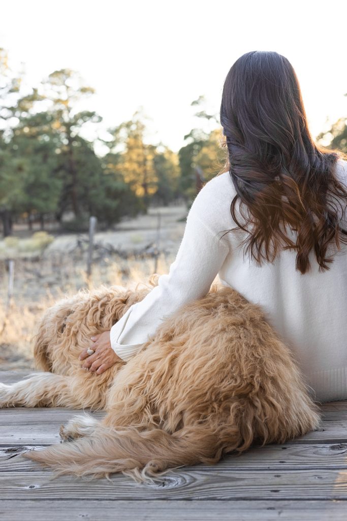 Model Yasmin and Goldendoodle Zayn enjoy the golden sunset glow from the porch of an A-Frame cabin near Flagstaff, Arizona.
