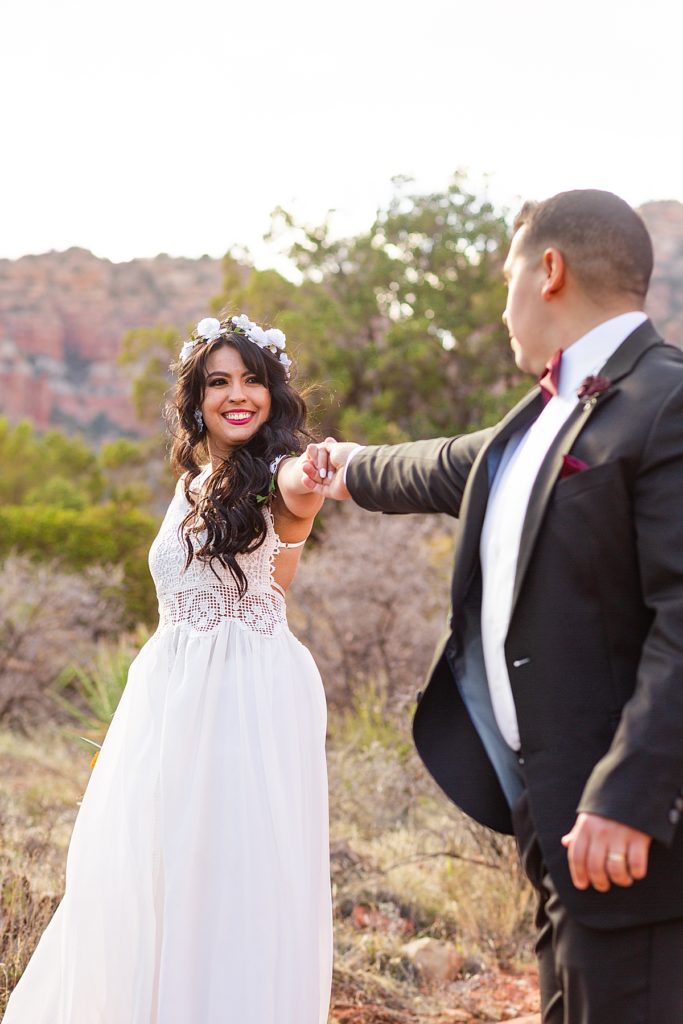 Husband dances with wife surrounded by the stunning Sedona red rocks during Anniversary portrait session.