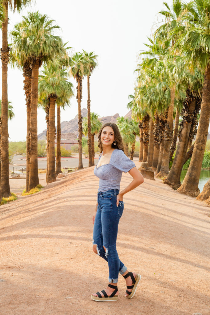2022 senior grad Kylie poses amidst the Papago Park palm trees during her portrait session