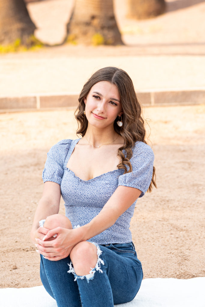 2022 senior grad Kylie smiles softly, looking off-camera during her senior portrait session