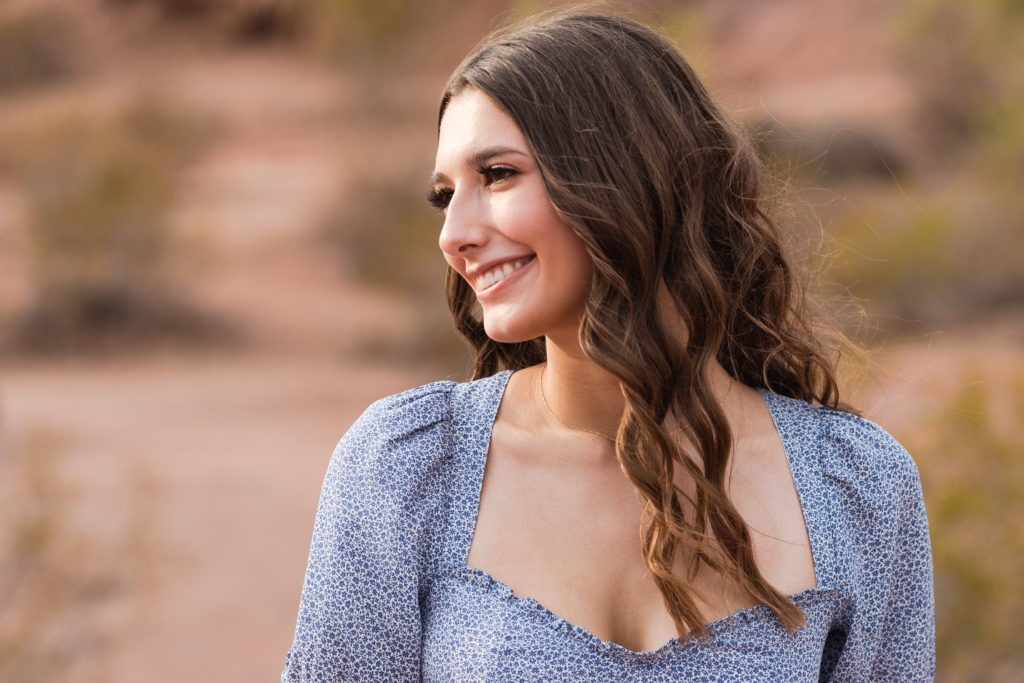 2022 senior grad Kylie softly smiles off camera at her mother during her portrait session