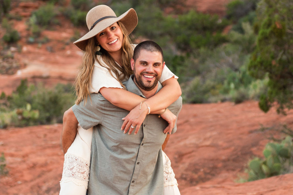 Nick and Bethany giggle during a piggy-back ride for an anniversary photo session in Sedona