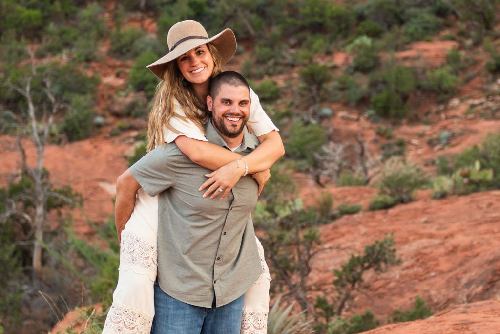 Nick and Bethany smile broadly during a piggy-back ride for an anniversary photo session in Sedona