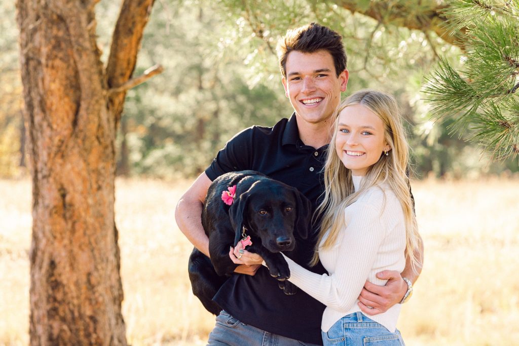Luke and Kirstin laugh as Corra their black lab looks into the camera.