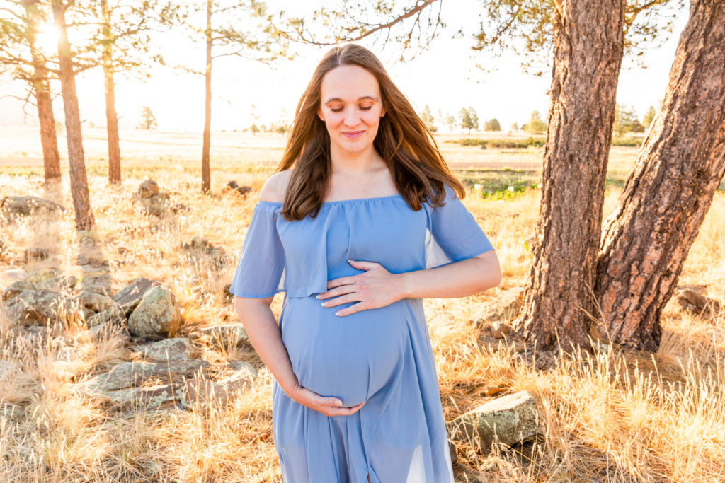 A soft moment in Flagstaff, Arizona during a maternity portrait photo session with photographer Bayley Jordan.