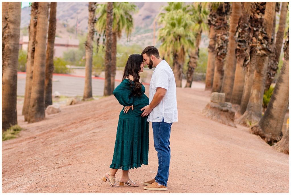 Gorgeous maternity couple nuzzles in close during an intimate moment during a portrait from Bayley Jordan Photography in Scottsdale, Arizona