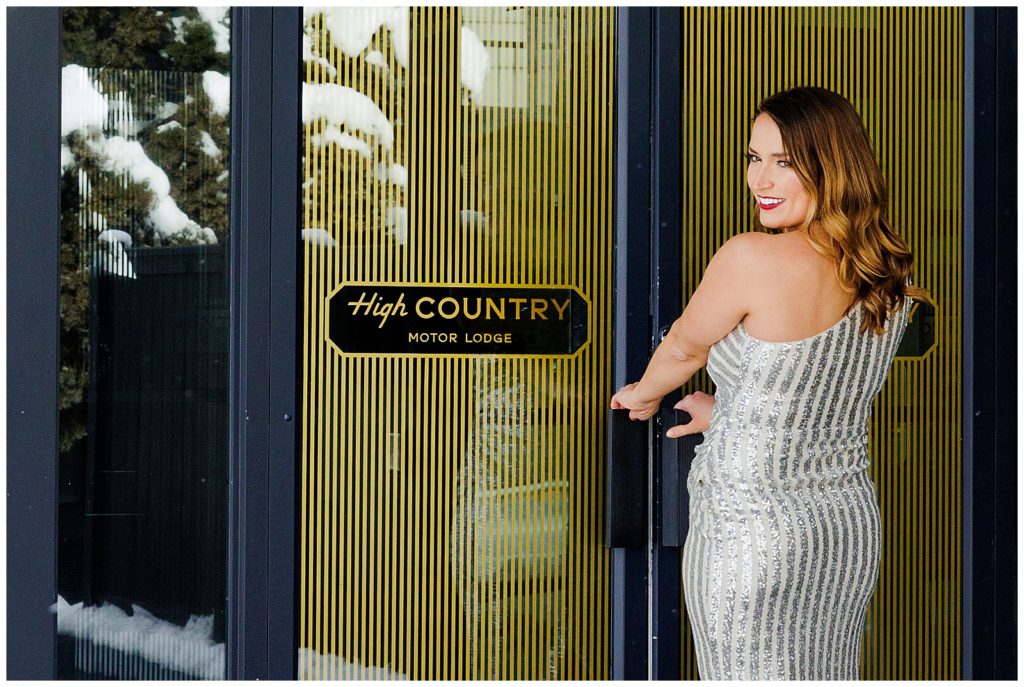 Sara shows off a stunning sparkling dress and the beautiful branding at the entrance of High Country Motor Lodge, in Flagstaff, AZ 