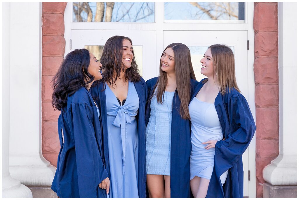 Four friends giggle during a portrait session with Bayley Jordan Photography in Flagstaff, AZ to celebrate graduation from NAU