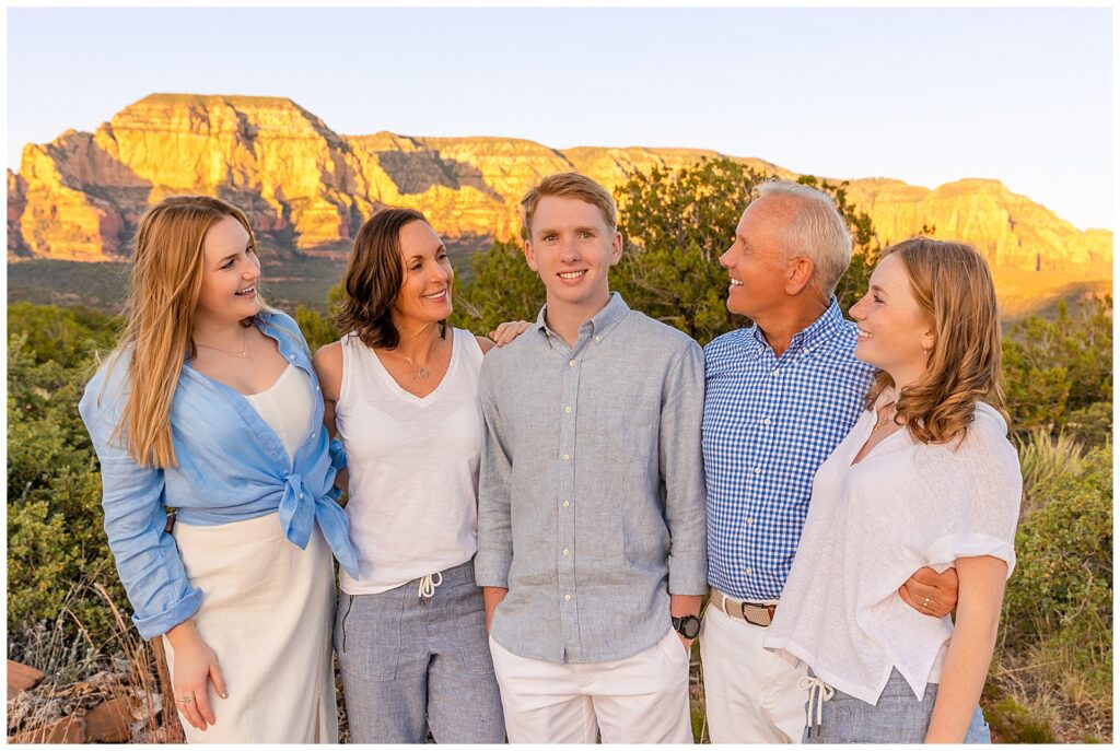 Family all smiles at graduating senior during a family portrait session in Sedona, Arizona. 