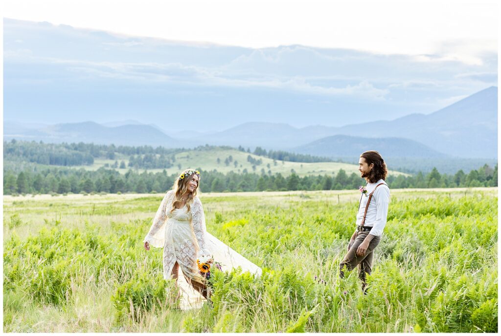 Brooke leads Eric through a field of flowers on the mountain top during their 10 year anniversary celebration in Flagstaff, Arizona. 