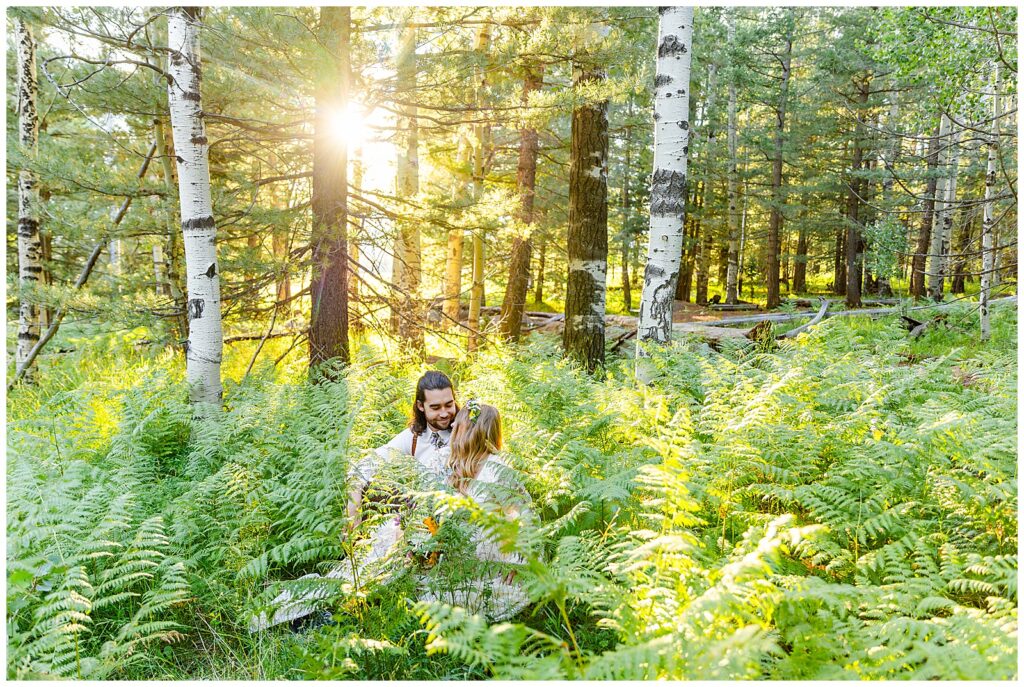 Brooke and Eric rest in the ferns, snuggling during their 10 year anniversary celebration in Flagstaff, Arizona. 