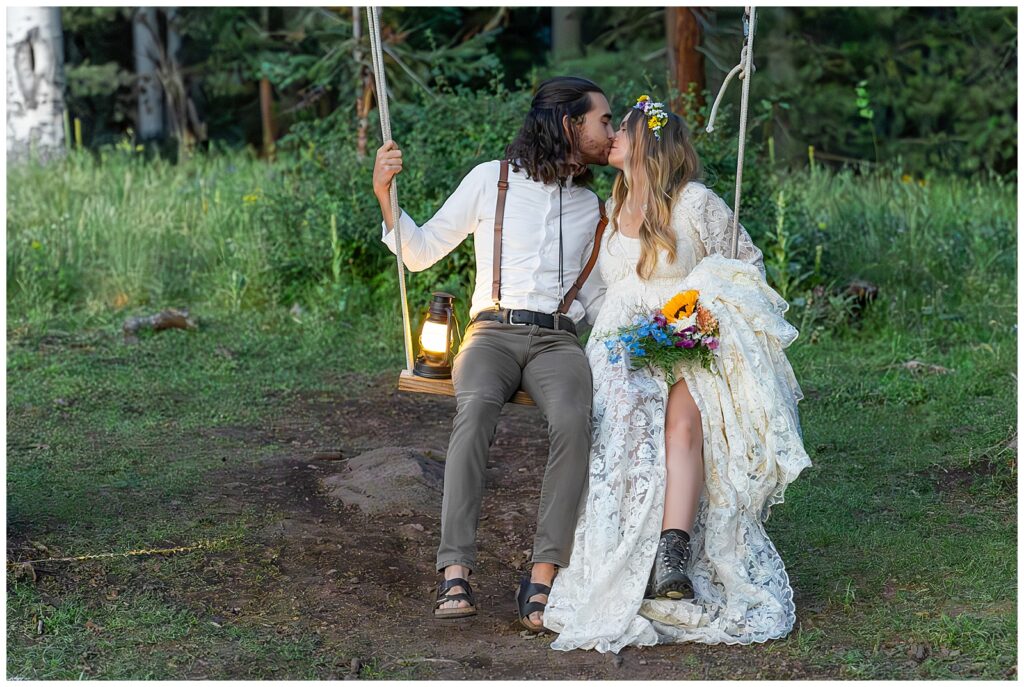 As dusk falls, Brooke and Eric share a kiss seated on the Aspen tree swing on the mountain during their 10 year anniversary celebration in Flagstaff, Arizona.  