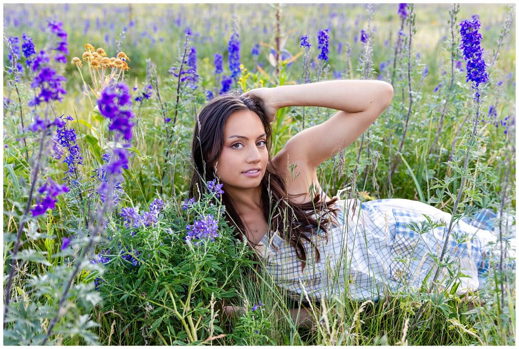 Holly peeks out from a field of purple flowers during a golden hour editorial portrait session with Bayley Jordan Photography in Flagstaff, Arizona