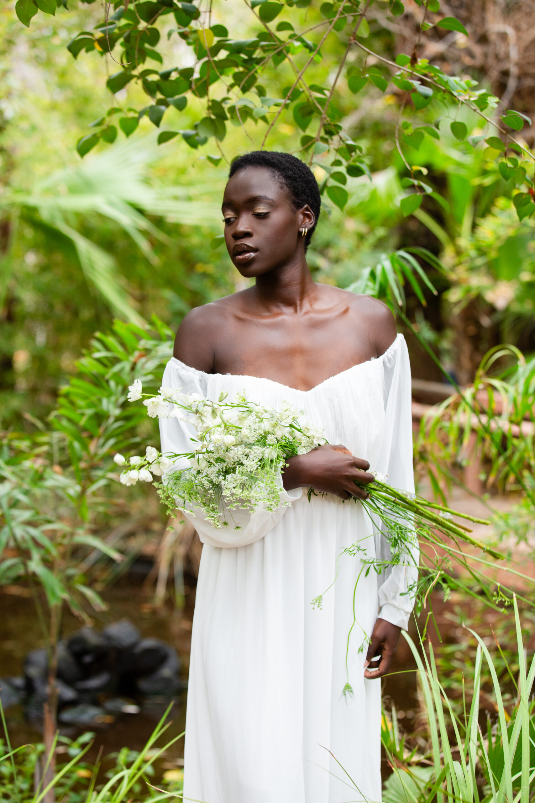 Image of a portrait photography client at sunset surrounded by gorgeous greenery in a white gown.