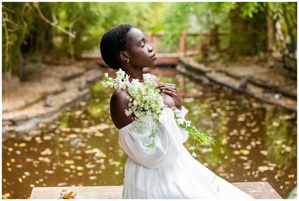 Image of a portrait photography client at sunset surrounded by gorgeous greenery in a white gown. 