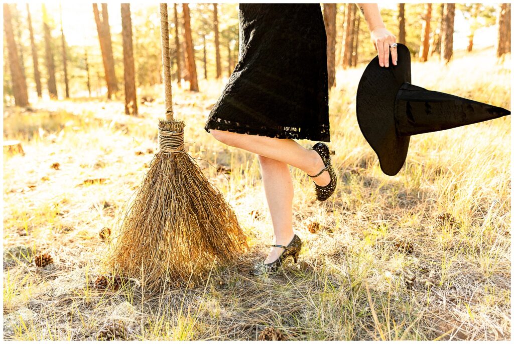 Details from Halloween portrait session with enchanted witch theme with Bayley Jordan Photography in Flagstaff, Arizona. Pictured are a rustic tan broomstick, stiletto black heels, and a pointed hat.