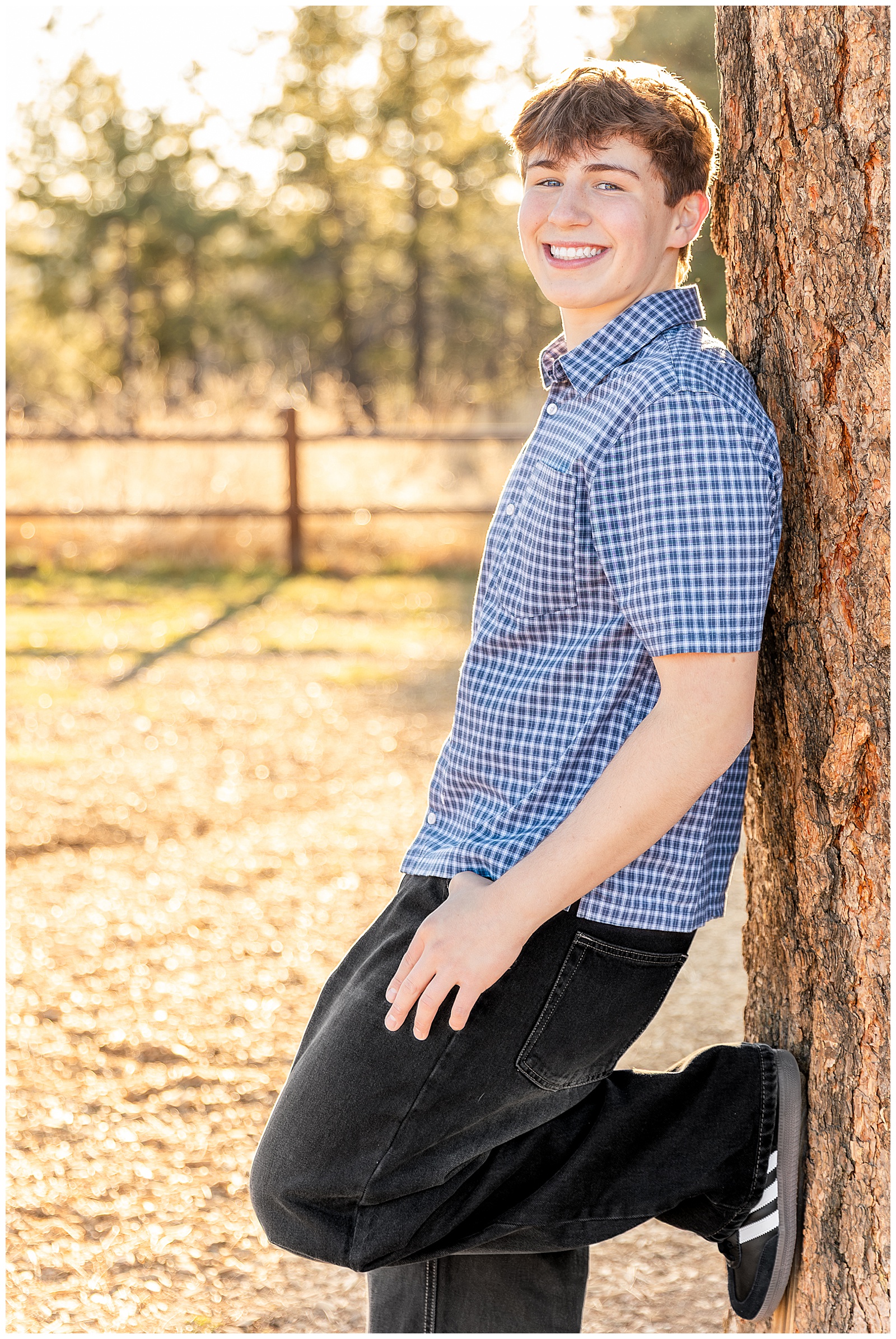 Flagstaff High School Graduate in dress clothes leaning against a Ponderosa Pine Tree at Sunset at Buffalo Park